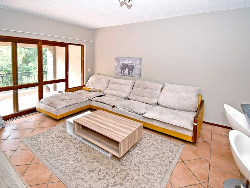 Open plan living area featuring tiled flooring and a large sliding glass door providing access to the balcony.