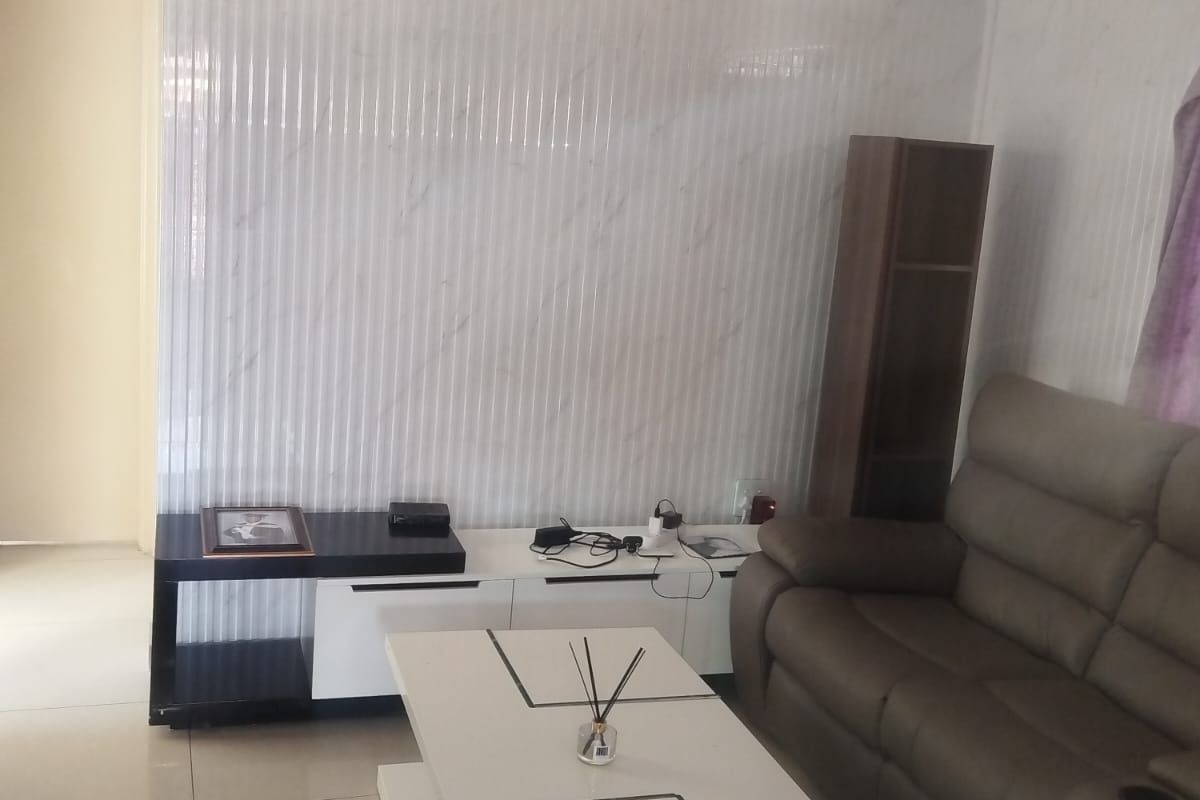 Living room featuring marble-effect wall cladding, tiled flooring, and decorative coving.