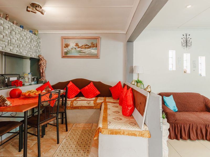 Open-plan living and dining area featuring built-in bench seating, tiled flooring, and a stone-clad feature wall, creating a connected and functional living space.
