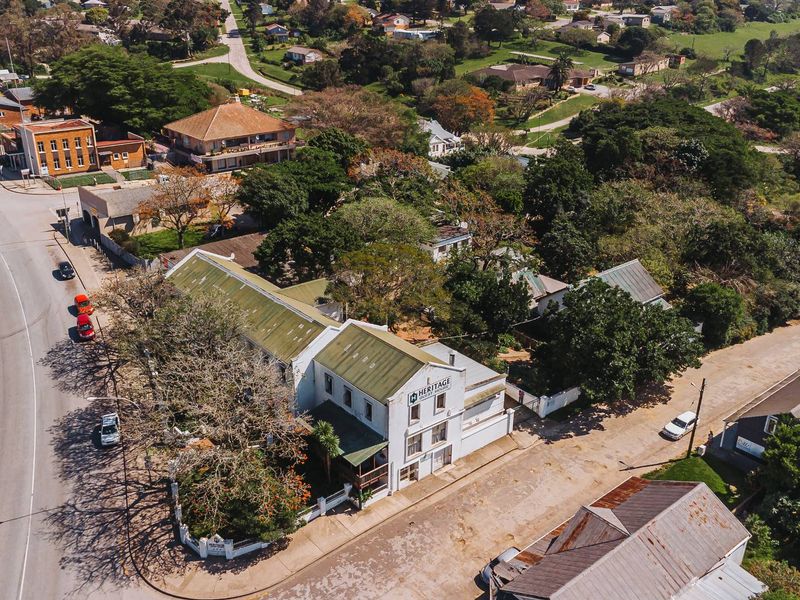 Aerial view of the property showing the building structure, roof profile, and surrounding street layout in a commercial setting.