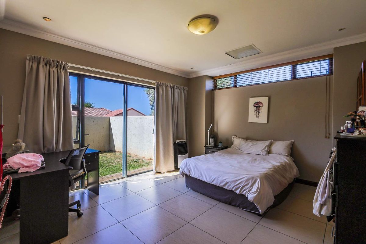 Spacious bedroom featuring large sliding glass doors that open directly to a private rear garden, providing ample natural light and outdoor access.