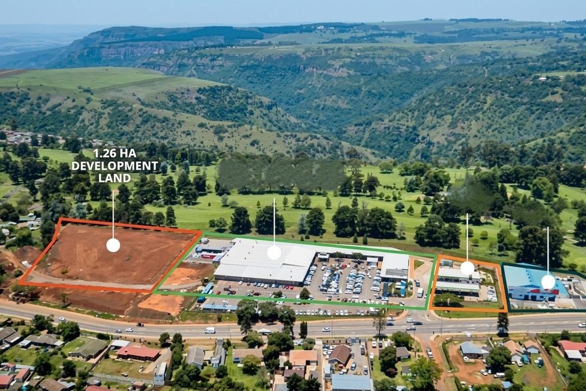 Aerial view of a commercial property complex featuring a 1.26-hectare vacant development plot, existing commercial buildings, and paved parking facilities.