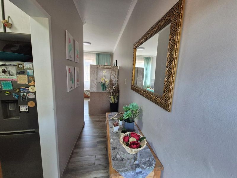 A functional hallway featuring tiled flooring and coved ceiling details, providing access to adjacent living areas.