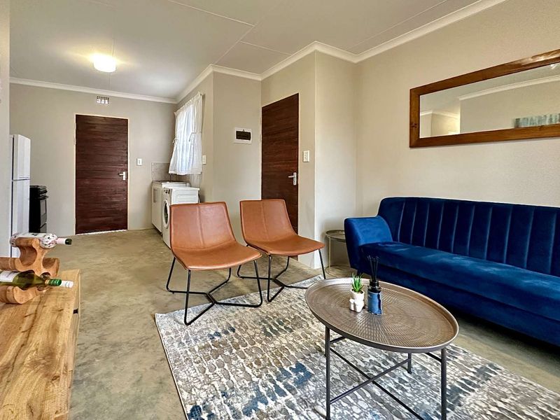 Open-plan living area featuring polished concrete floors, coved ceilings, and integrated laundry facilities, offering a functional and modern layout.