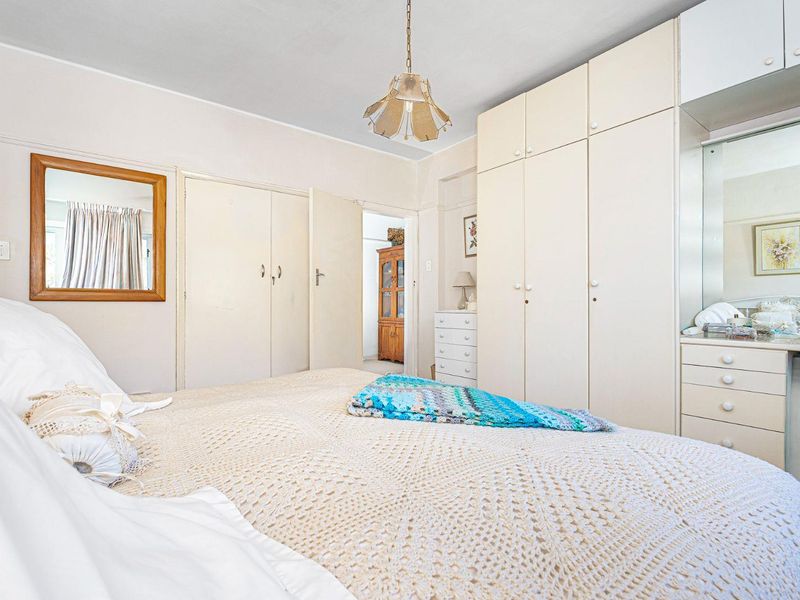 A bedroom featuring extensive built-in cabinetry, including wardrobes and a vanity unit, providing ample storage space.
