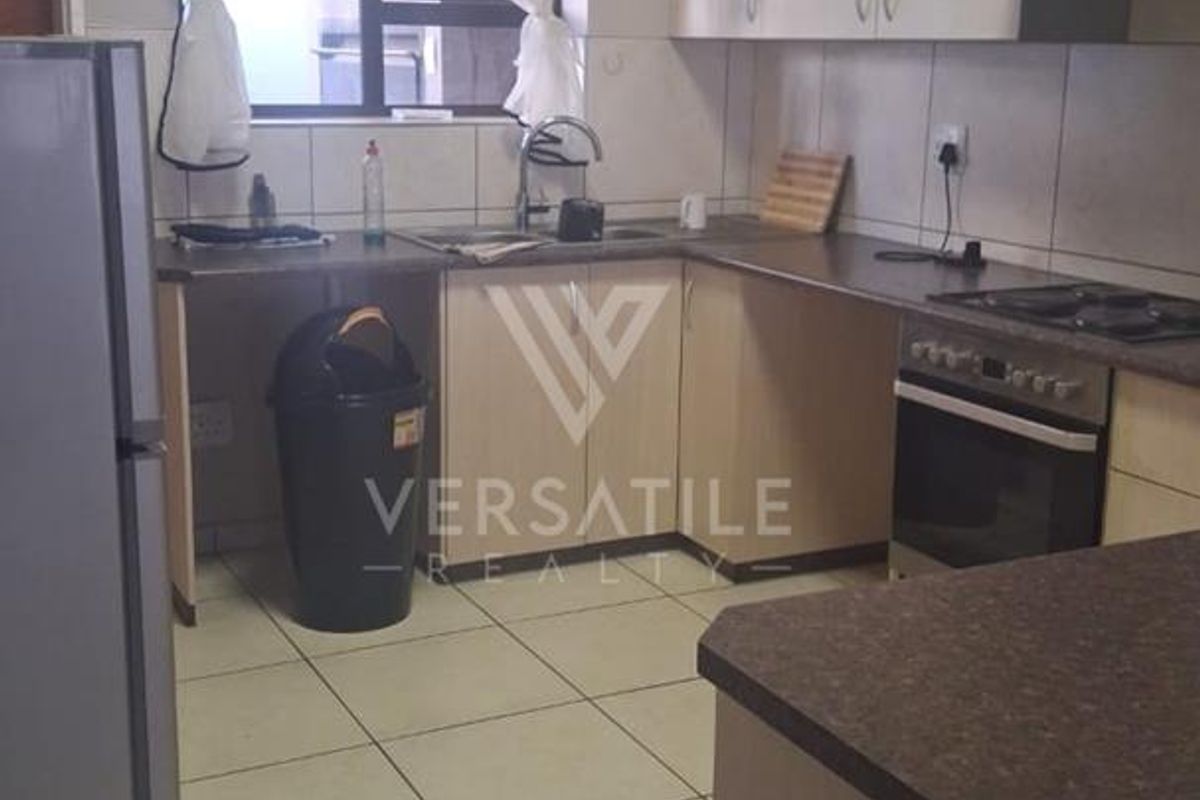 A functional kitchen featuring laminate cabinetry, tiled backsplash, built-in oven, hob, and extractor fan with tiled flooring throughout.