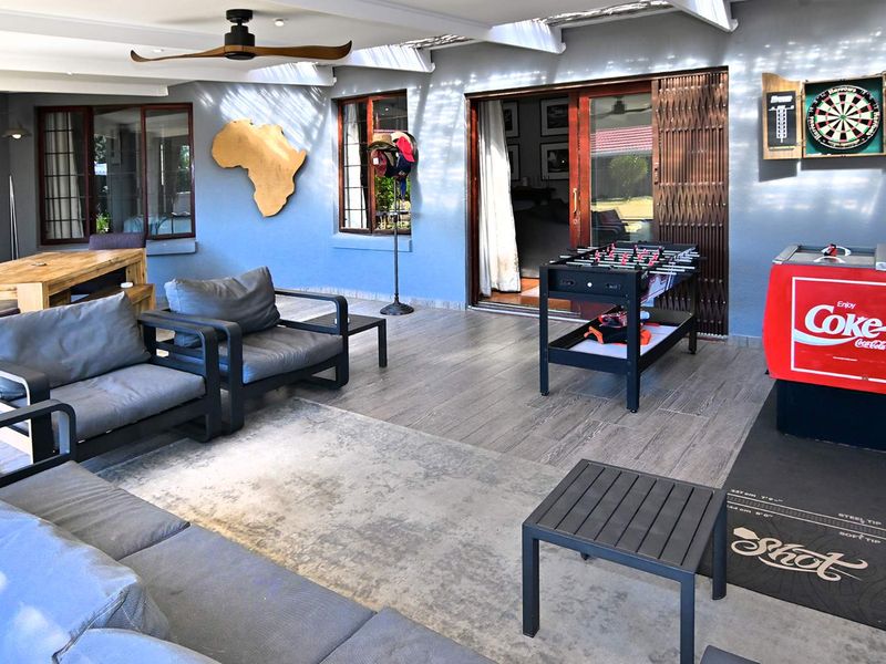 A spacious covered patio featuring tiled flooring, a ceiling fan, and large sliding glass doors providing seamless access to the interior living areas.
