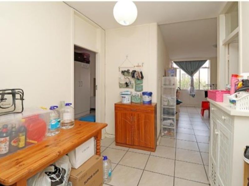 A functional hallway area featuring tiled flooring and neutral wall finishes, providing access to adjacent rooms within the apartment.