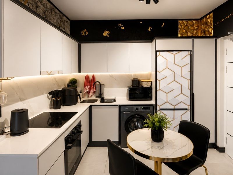 Modern, well-appointed kitchen featuring sleek white cabinetry, integrated appliances, stone-look backsplash, and sophisticated under-cabinet lighting in a compact, efficient layout.