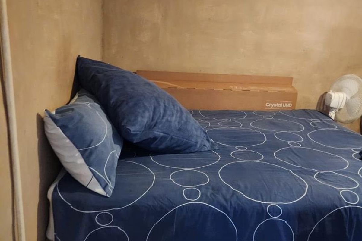 A bedroom space featuring unfinished wall surfaces and exposed electrical wiring, requiring cosmetic updates and finishing to improve the overall condition.