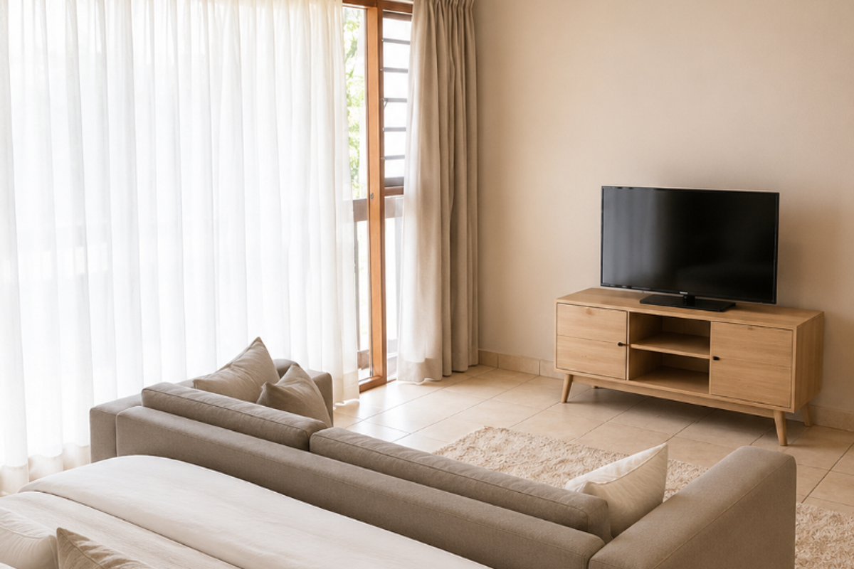 A well-lit bedroom featuring neutral tones, tiled flooring, and a sliding glass door providing access to the outdoors.