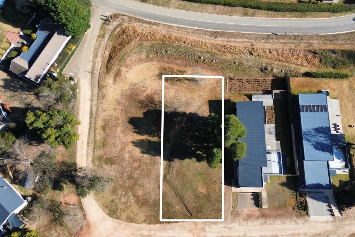 Aerial view of a vacant residential plot with clear boundary markings, situated in a developed neighborhood.