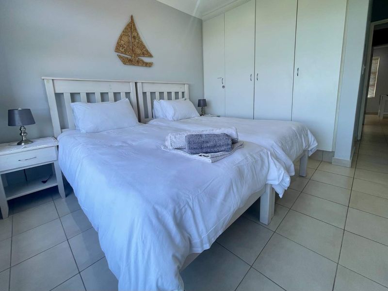 A bedroom featuring tiled flooring and built-in cupboards, providing functional storage space.