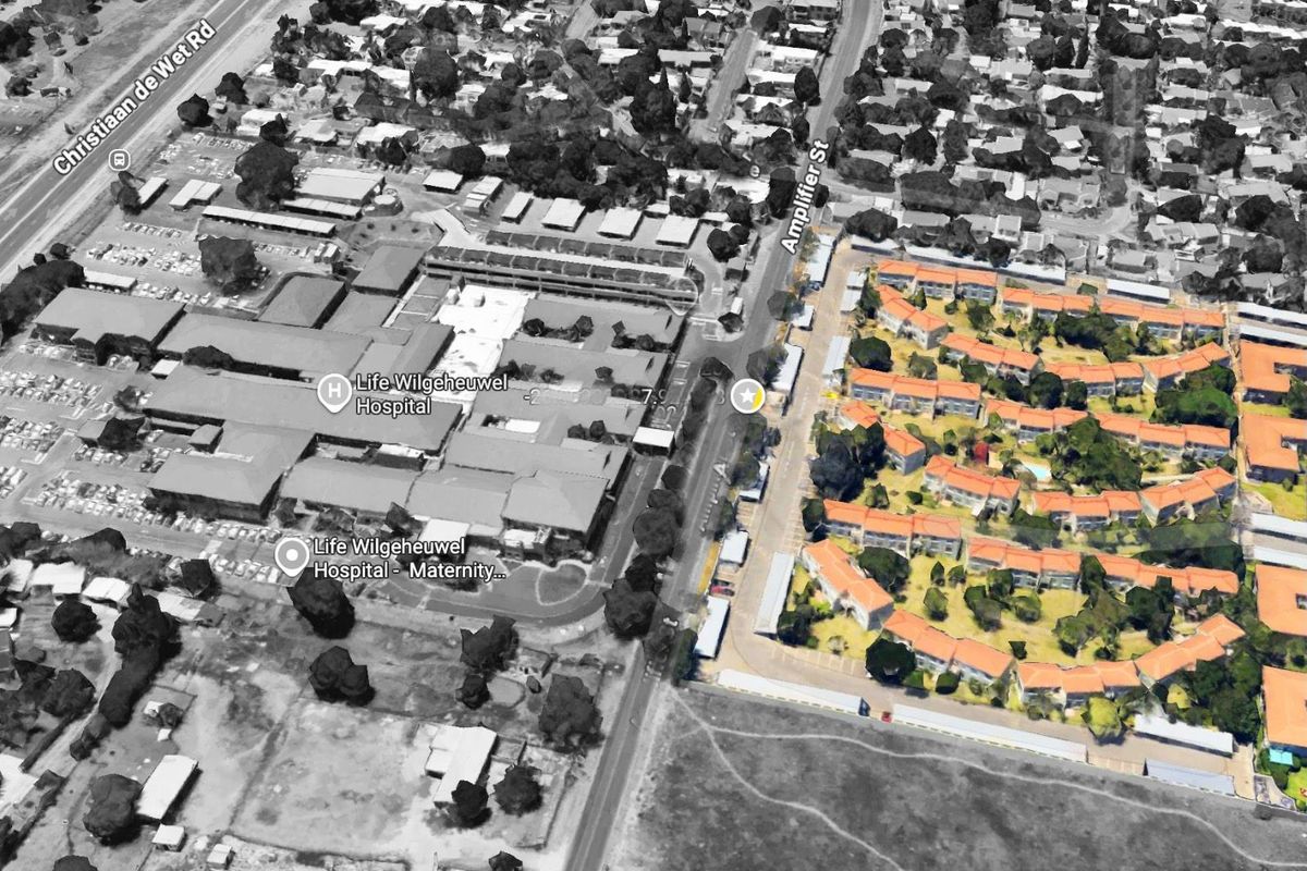 Aerial view of the residential apartment complex situated in proximity to local infrastructure and major road access.