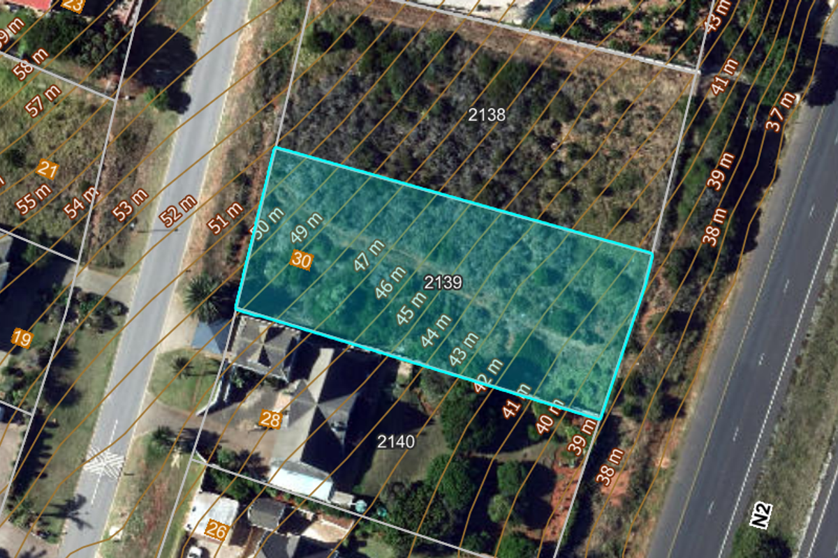 Aerial view of a vacant residential plot with topographical contour lines overlaid, highlighting the property boundaries and surrounding landscape.