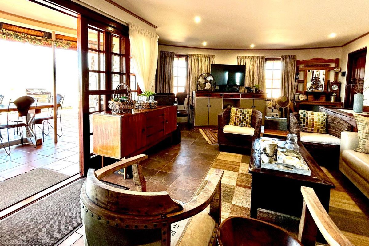 Spacious living room featuring tiled flooring and large sliding glass doors that open onto a covered patio area.