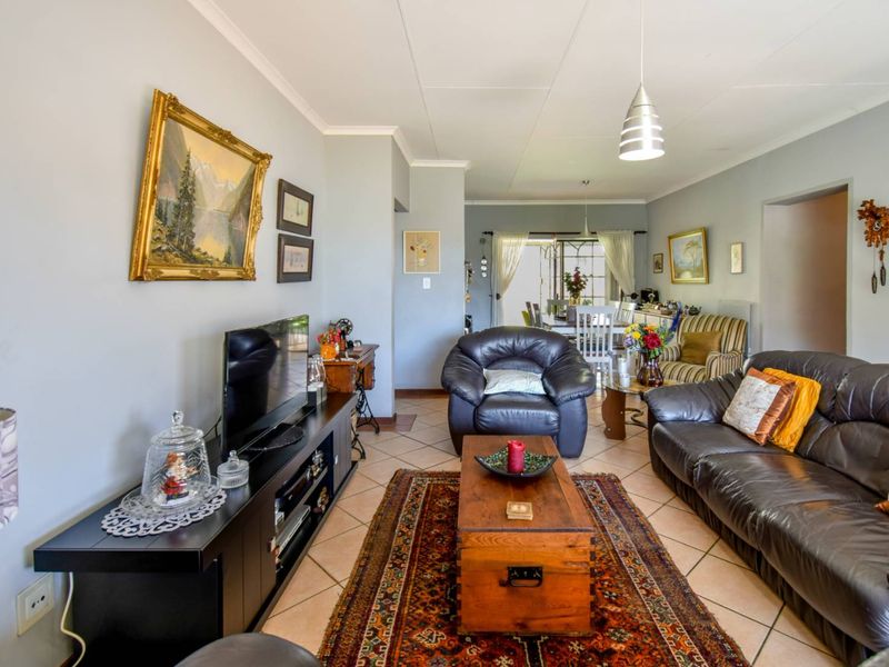 Spacious open-plan living and dining area featuring tiled flooring, neutral walls, and sliding glass doors leading to the outdoor space.