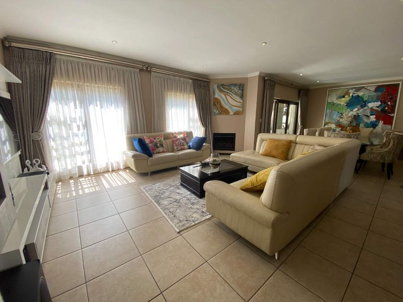 Spacious living room featuring tiled flooring, a built-in fireplace, and large sliding glass doors that provide ample natural light.