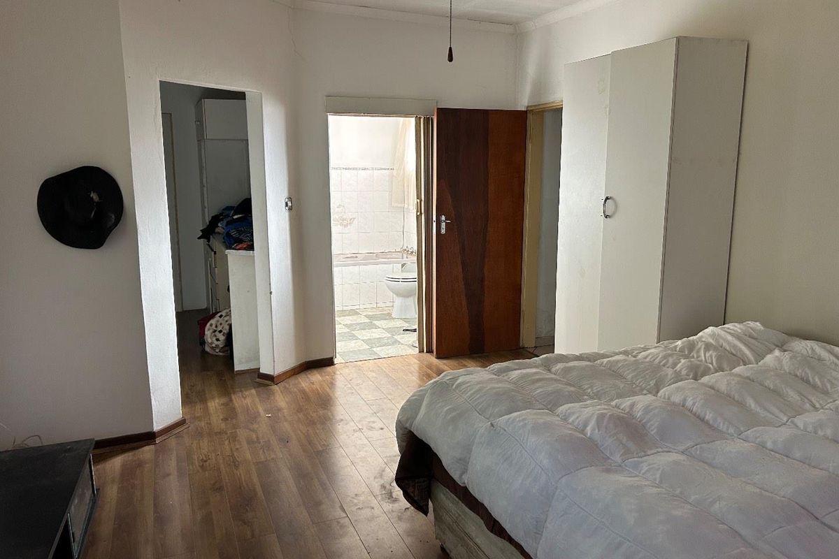 Bedroom featuring laminate flooring, built-in wardrobe, and direct access to an en-suite bathroom.