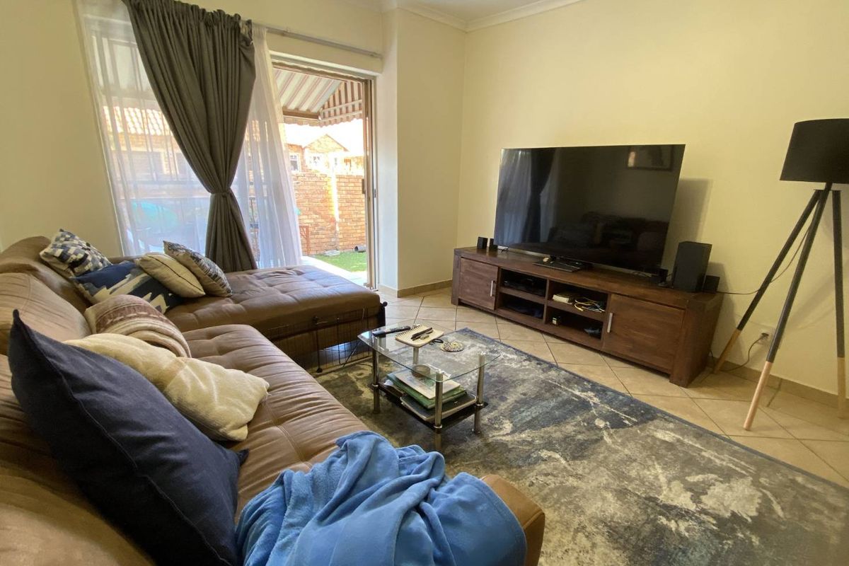 A comfortable living room featuring tiled flooring and a sliding glass door providing direct access to the outdoor patio area.