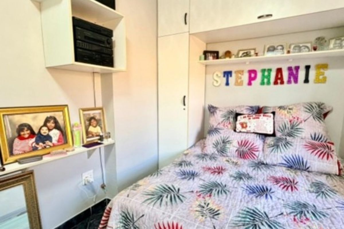 A compact bedroom featuring built-in cupboards and overhead storage cabinetry, providing efficient use of space.