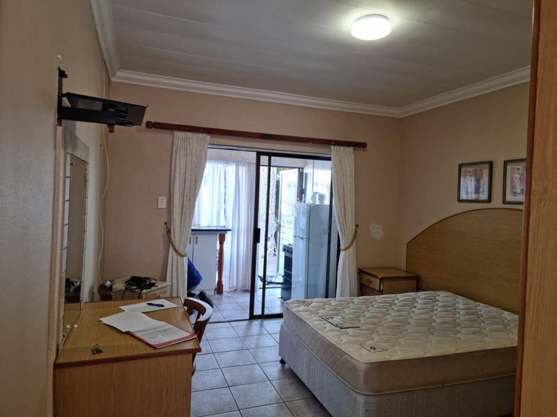 Bedroom featuring tiled flooring, crown molding, and a sliding glass door providing access to an outdoor area.