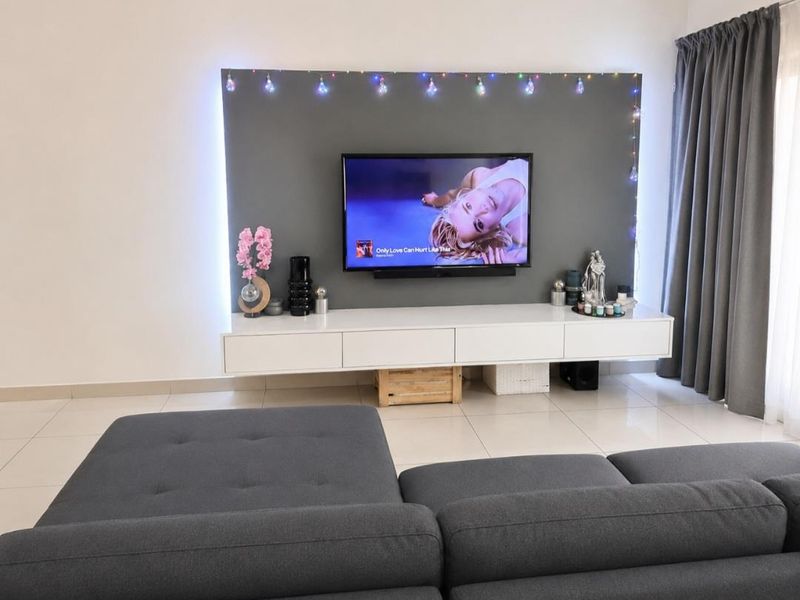A modern living room featuring a sleek, wall-mounted media console and a dedicated feature wall with integrated lighting.