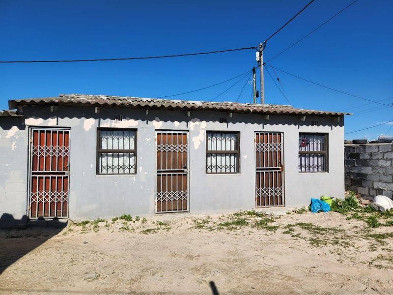Front elevation of a single-story dwelling featuring multiple entry points with security gates and a corrugated roof structure.