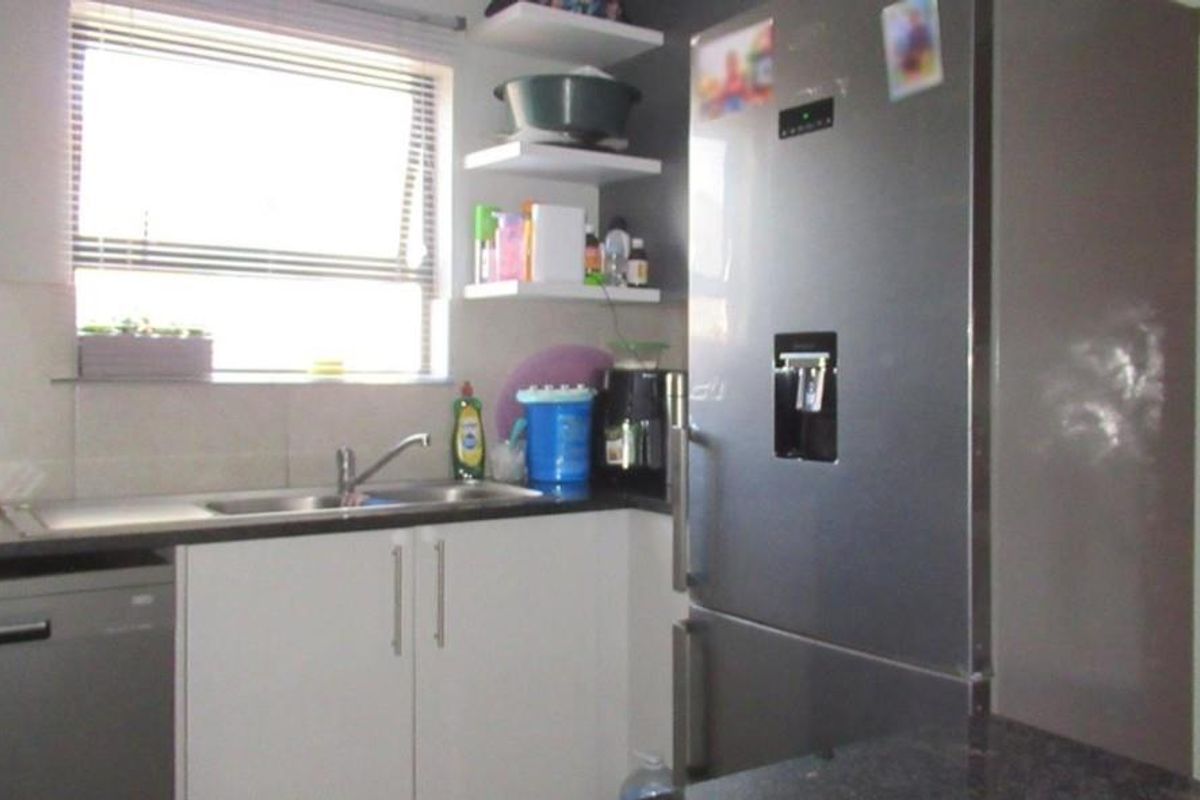A functional kitchen featuring modern cabinetry, a stainless steel sink, and space for a large refrigerator.