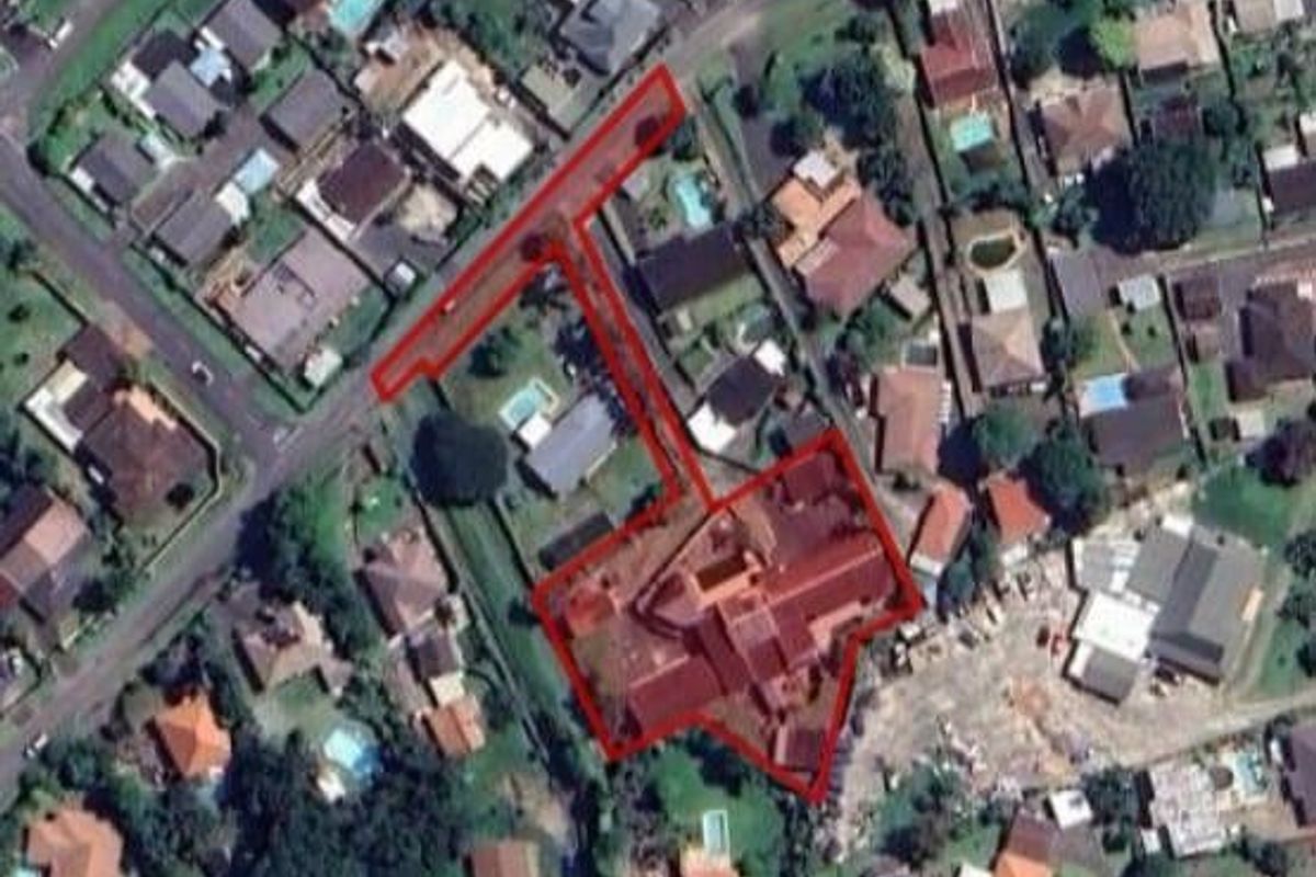 Aerial satellite view showing the property boundary, roof structure, and driveway access within the surrounding residential neighborhood.