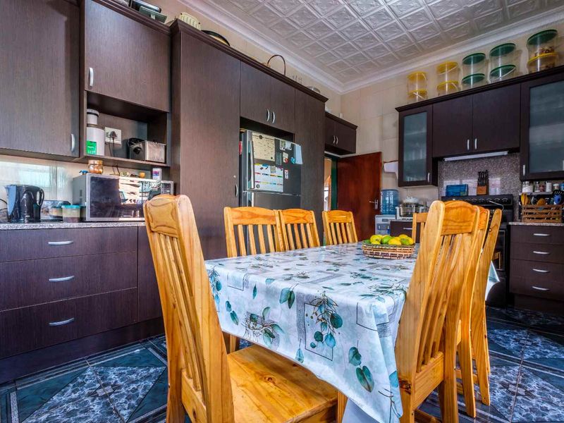 A functional kitchen featuring dark wood cabinetry, patterned tile flooring, and a decorative coffered ceiling, providing ample storage and workspace.