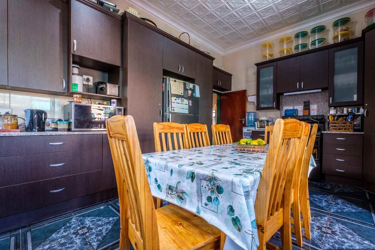 A functional kitchen featuring dark wood cabinetry, patterned tile flooring, and a decorative coffered ceiling, providing ample storage and workspace.