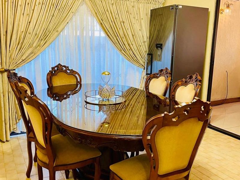 A dining room featuring tiled flooring, cornice detailing, and a wall-mounted split-system air conditioner.