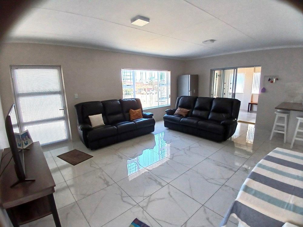 SPACIOUS open plan Living Area; BBQ Room on far right and front door on our left.