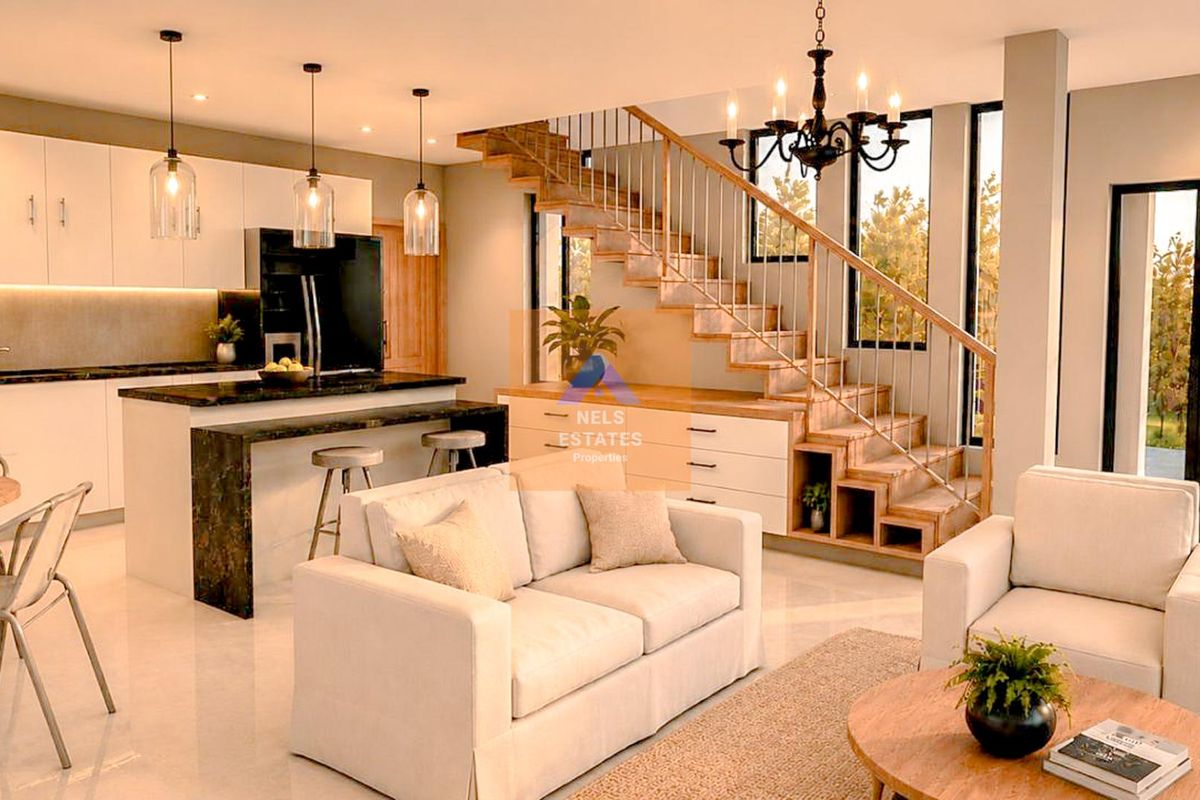 Modern open-plan living area featuring a sleek kitchen with stone island, elegant staircase with integrated storage, and bright, contemporary finishes throughout.