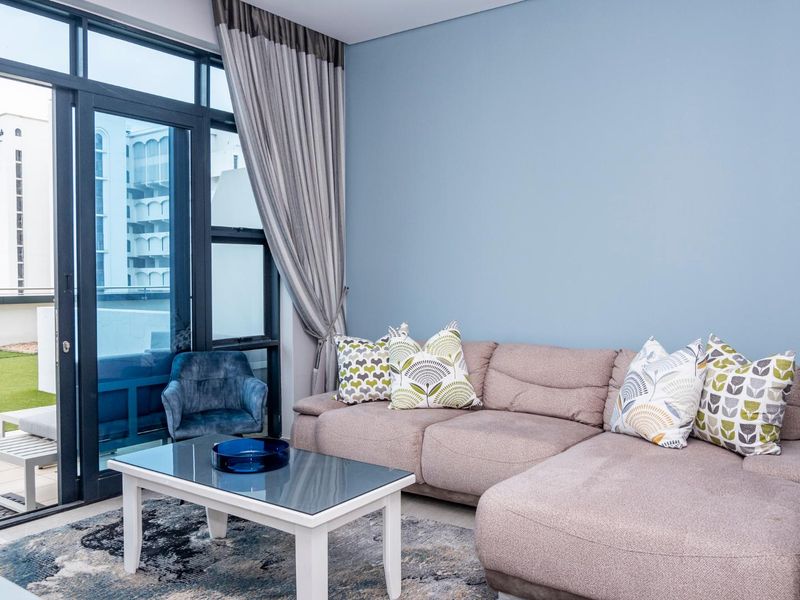 A bright living room featuring large sliding glass doors that provide access to an outdoor balcony area and allow for ample natural light.