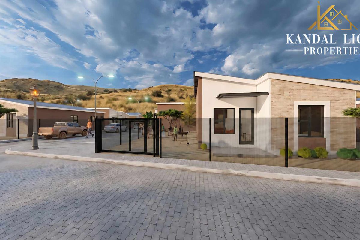 A modern townhouse exterior featuring stone cladding, a paved driveway, and secure gated access within a well-planned residential development.