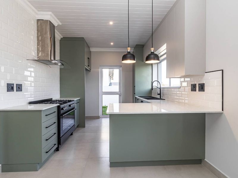 Modern kitchen featuring sage green cabinetry, white quartz countertops, subway tile backsplash, gas stove, and a tongue and groove ceiling.
