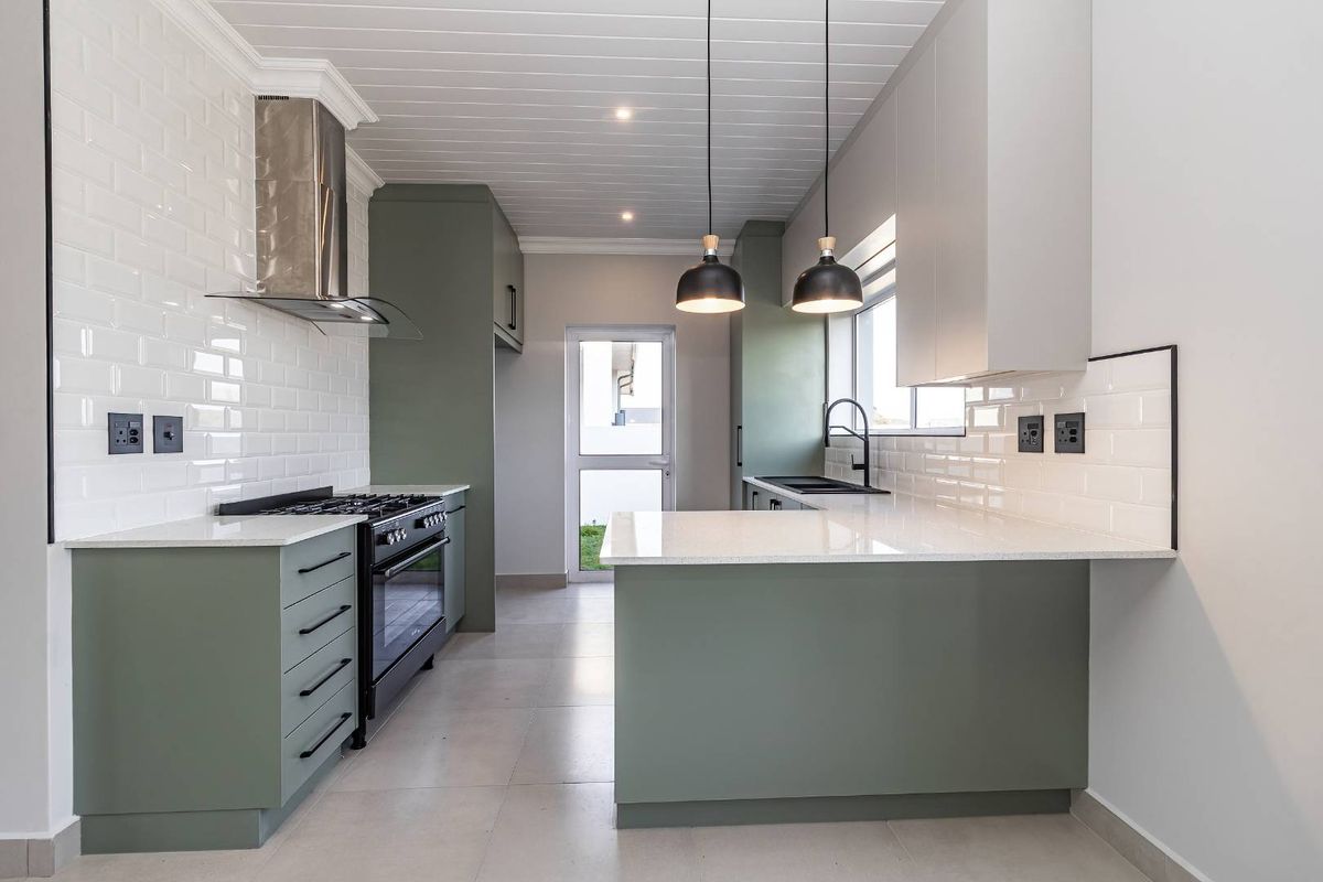 Modern kitchen featuring sage green cabinetry, white quartz countertops, subway tile backsplash, gas stove, and a tongue and groove ceiling.