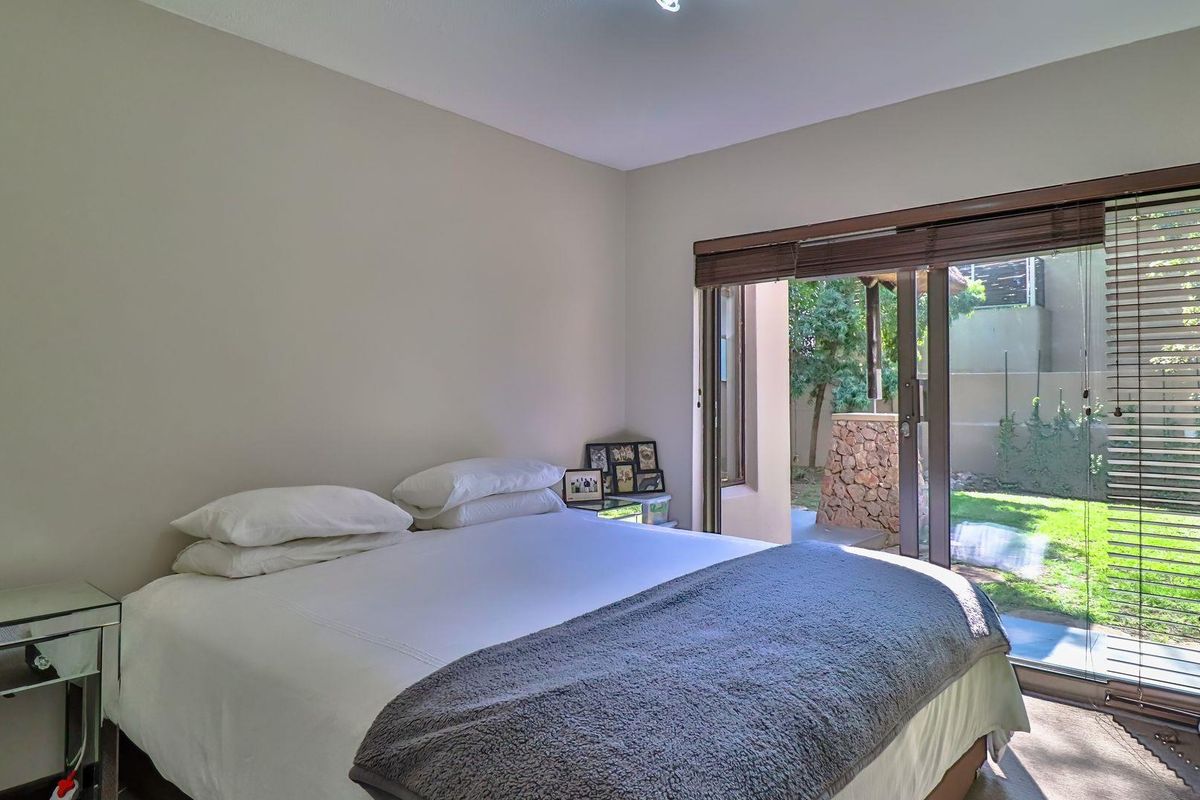 A bright bedroom featuring large sliding glass doors that provide direct access to the private garden area.
