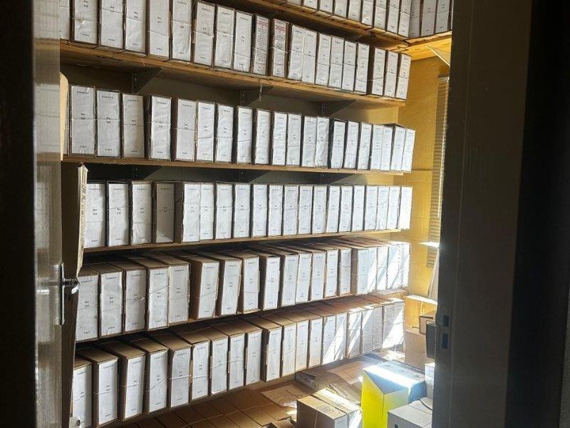 A utility storage room featuring extensive floor-to-ceiling built-in shelving units designed for organized document or inventory storage.