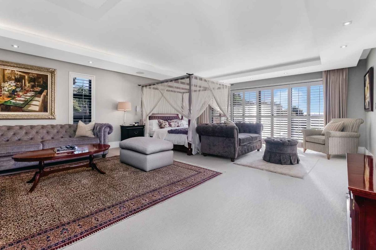 Spacious master bedroom suite featuring recessed ceiling lighting, plantation shutters, and direct access to an outdoor area.