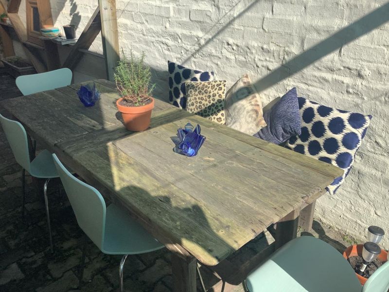 A rustic outdoor patio area featuring a painted brick wall and paved flooring, ideal for casual alfresco dining.