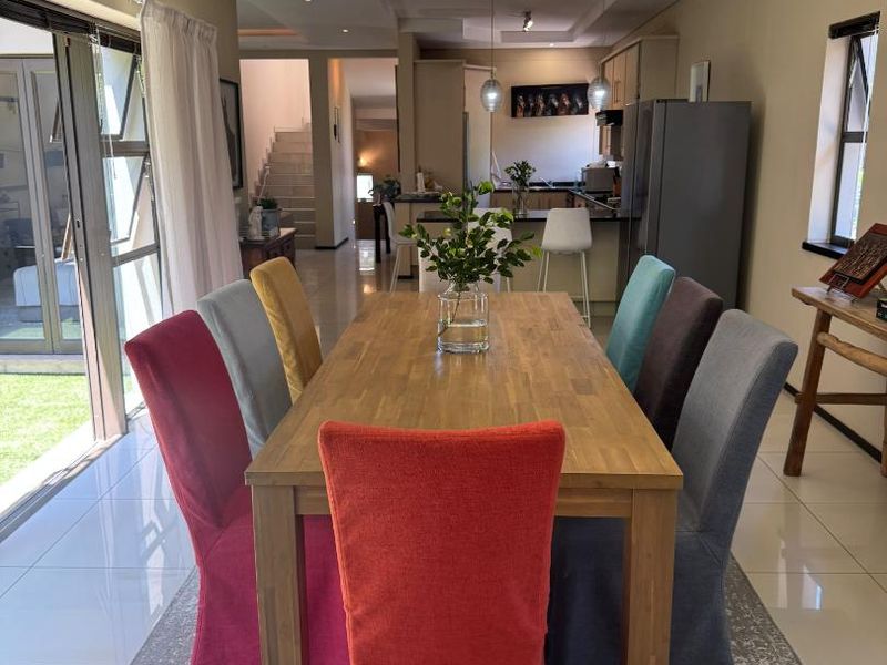 Spacious open-plan dining and kitchen area featuring tiled floors, recessed ceiling details, and large sliding doors leading to the garden.