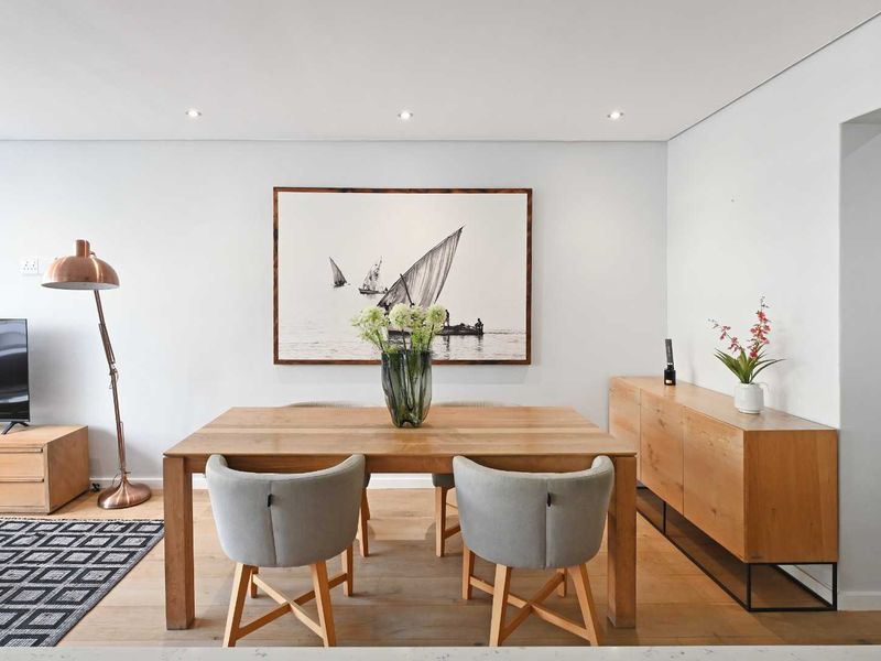 A bright and modern dining area featuring warm timber flooring and recessed downlighting, creating a clean and inviting space.