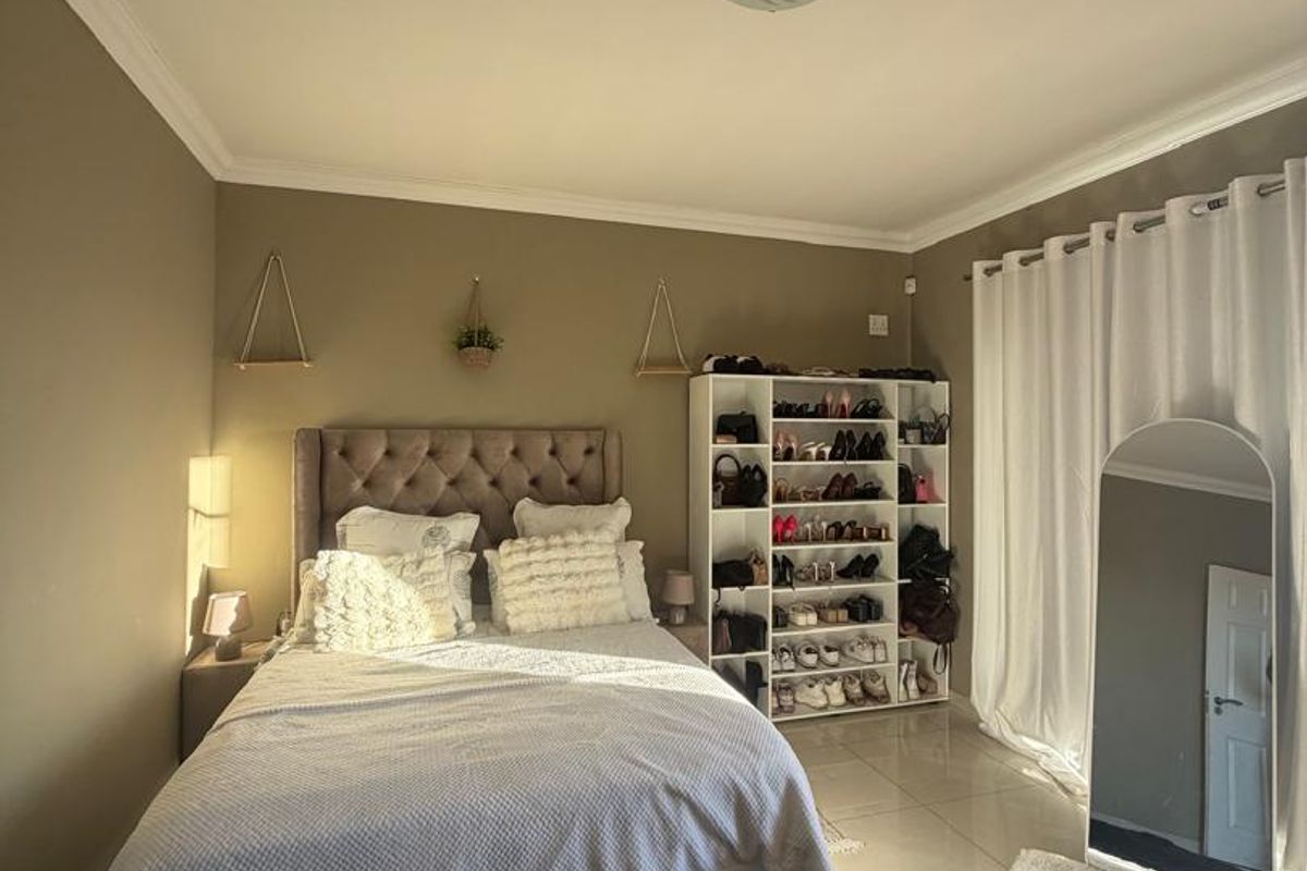 A well-maintained bedroom featuring neutral wall tones, tiled flooring, and coved cornicing, offering a bright and comfortable living space.