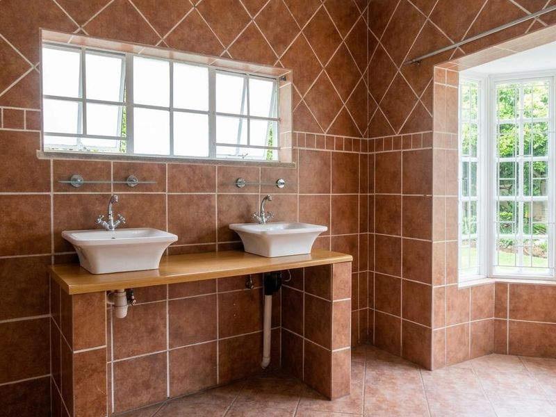 Spacious bathroom featuring a double vanity with vessel sinks, tiled walls and flooring, and a bright bay window.