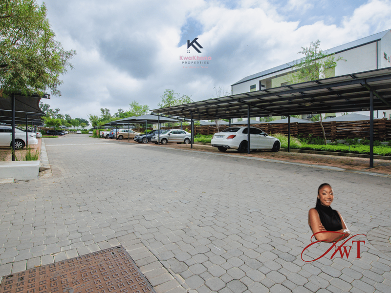 A well-maintained apartment complex parking area featuring covered parking bays and paved driveway surfaces.