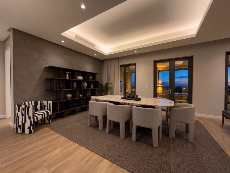 Elegant dining room featuring a recessed ceiling with cove lighting, timber flooring, and double glass doors leading to an outdoor area.