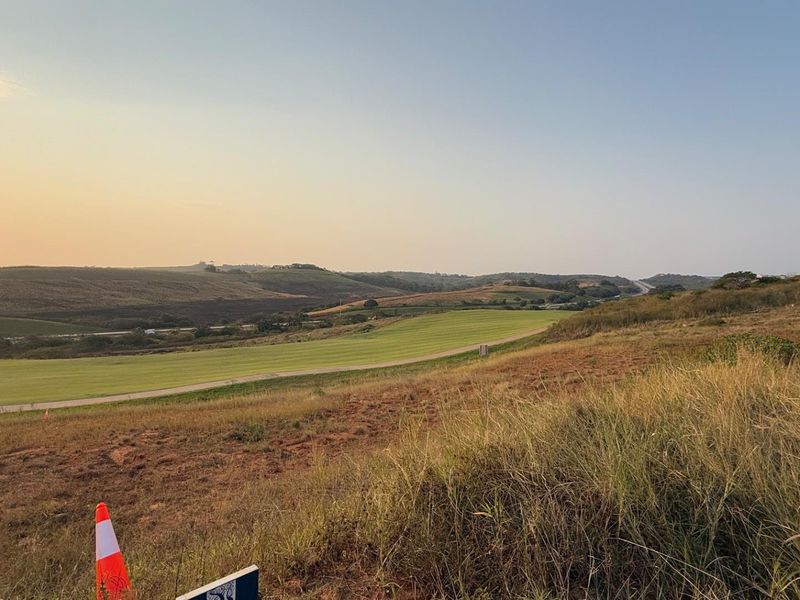 A wide-angle view of the vacant residential land, showcasing the natural topography and surrounding landscape.